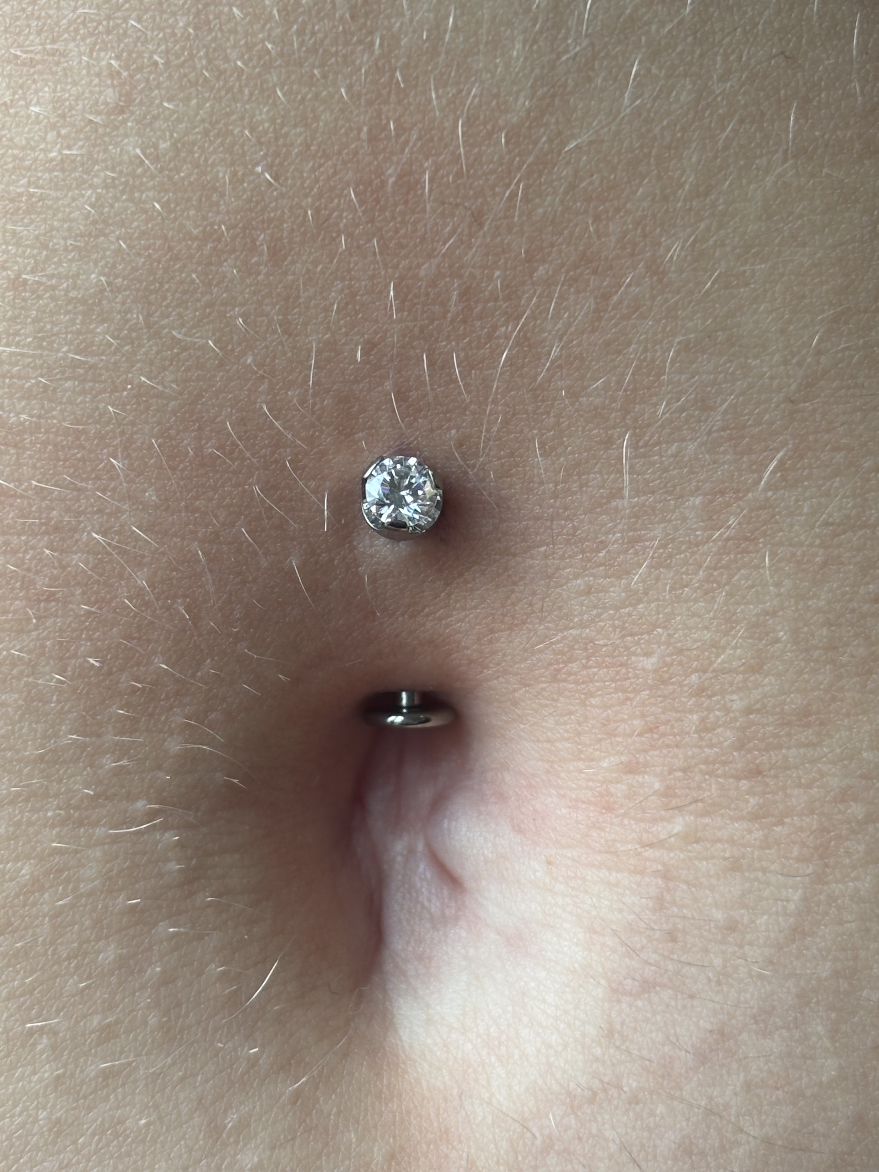Navel piercing with crystal stud top and silver ball bottom