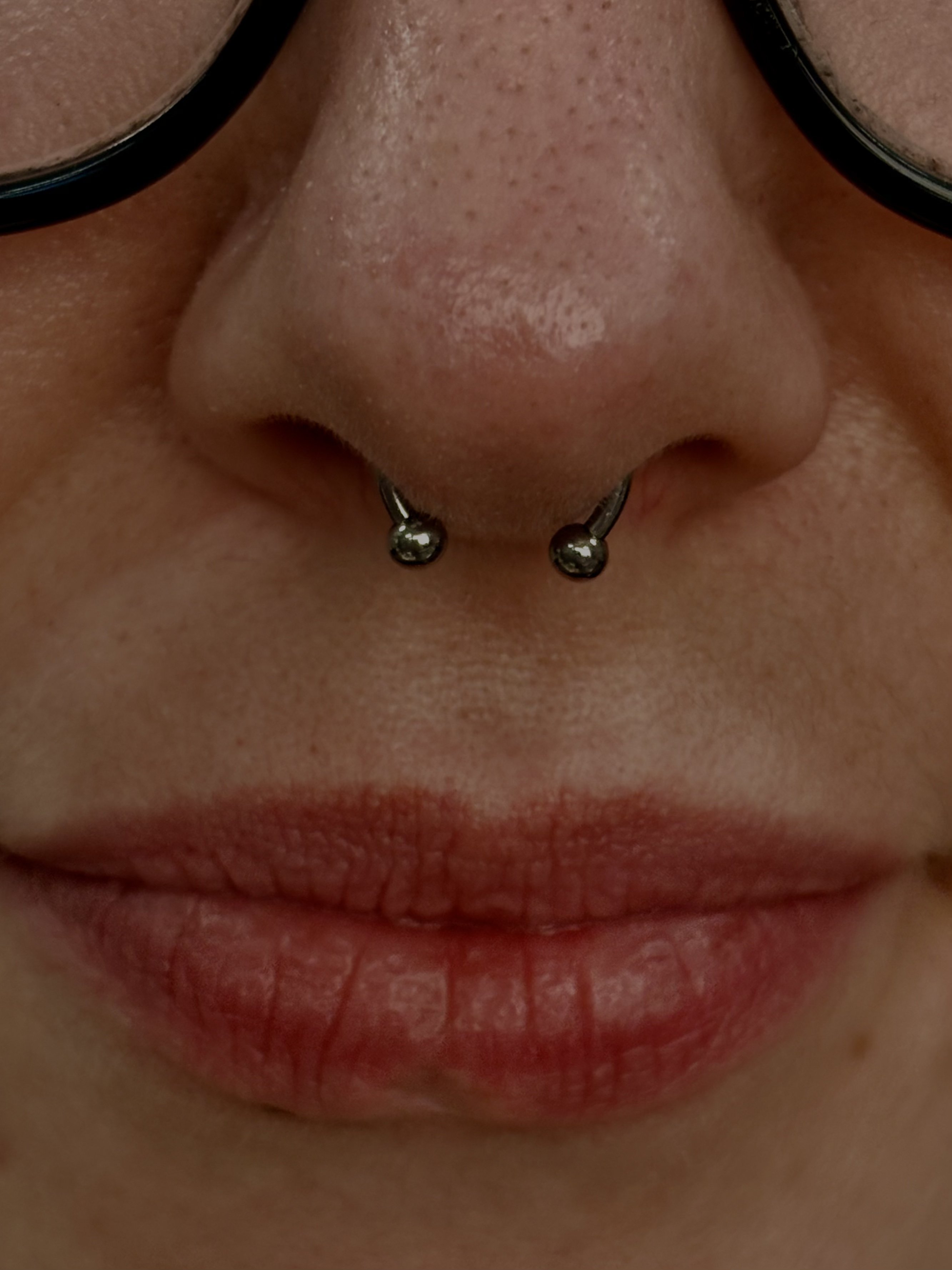 Septum piercing with silver horseshoe ring