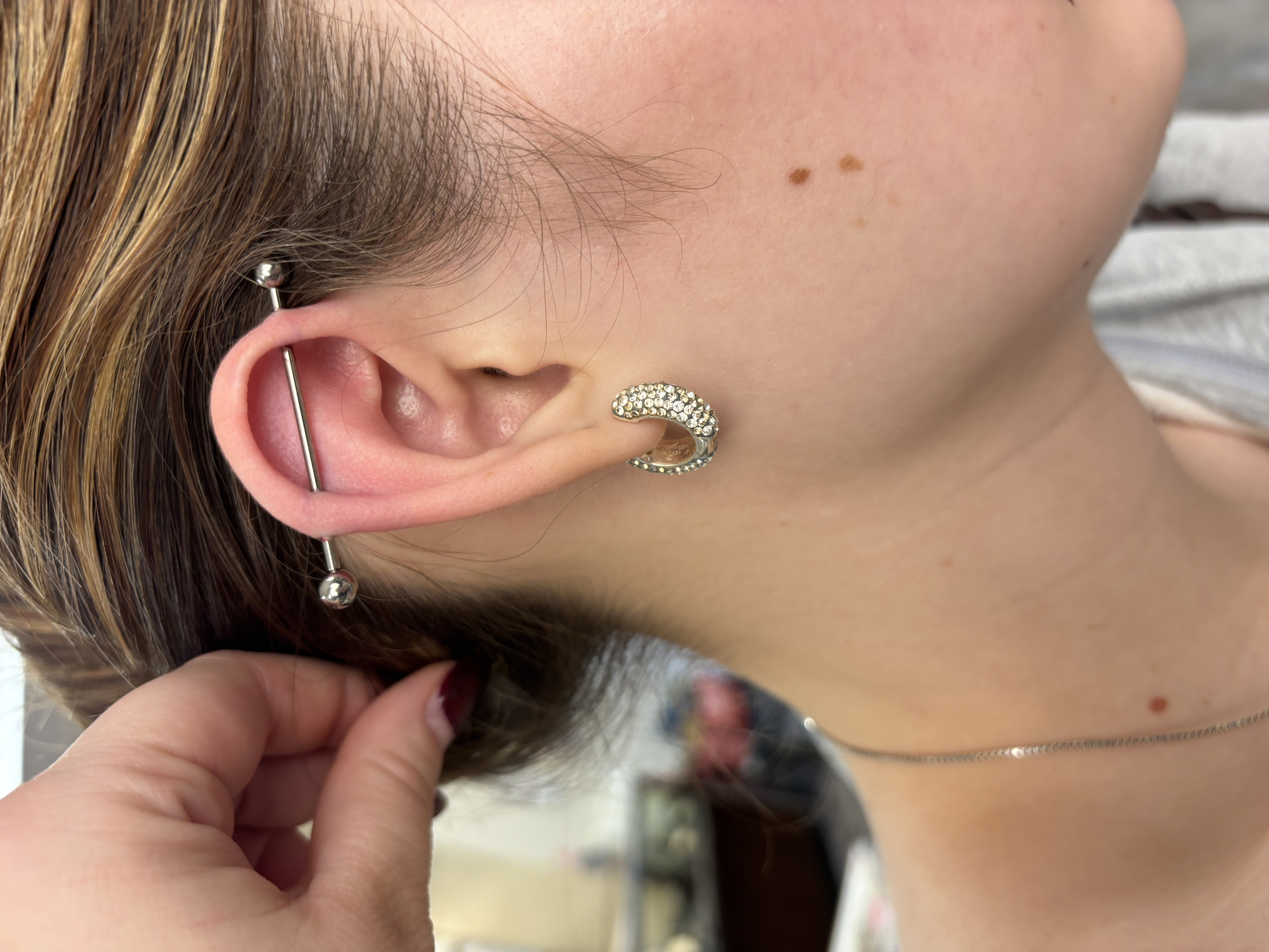 Industrial ear piercing with crystal hoop in lobe