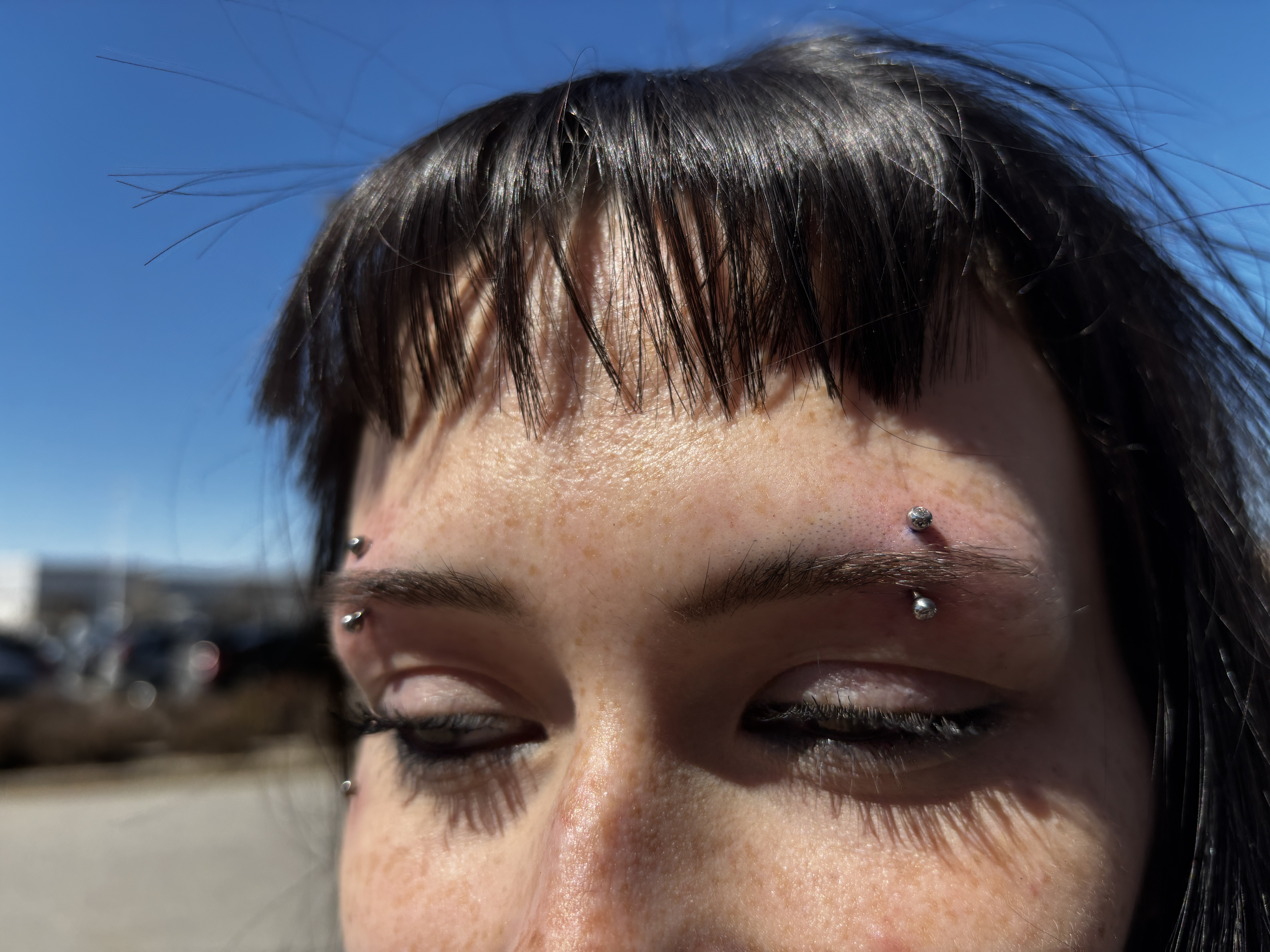 Double eyebrow piercings with titanium balls