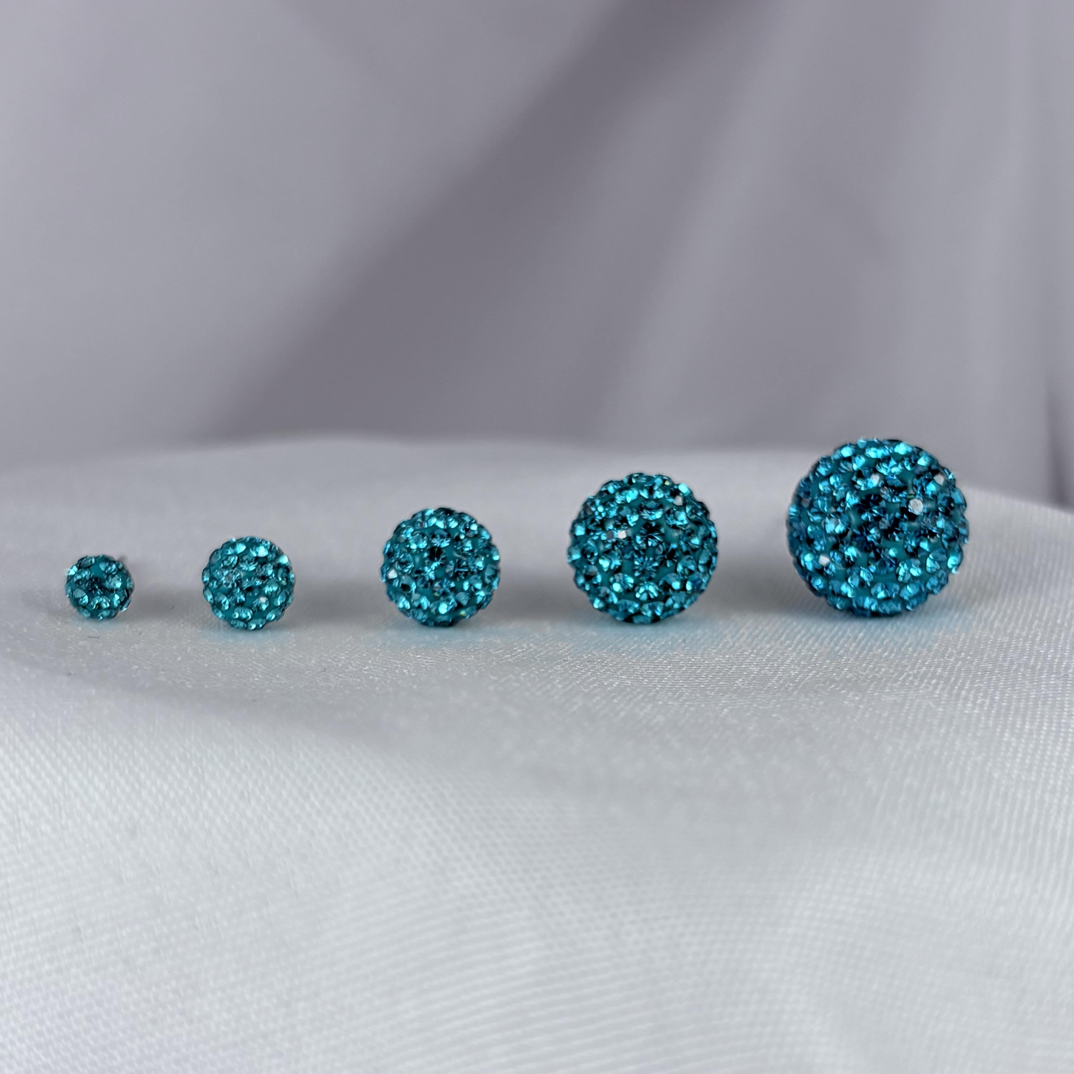 Teal Crystal Ball earrings displayed in five sizes