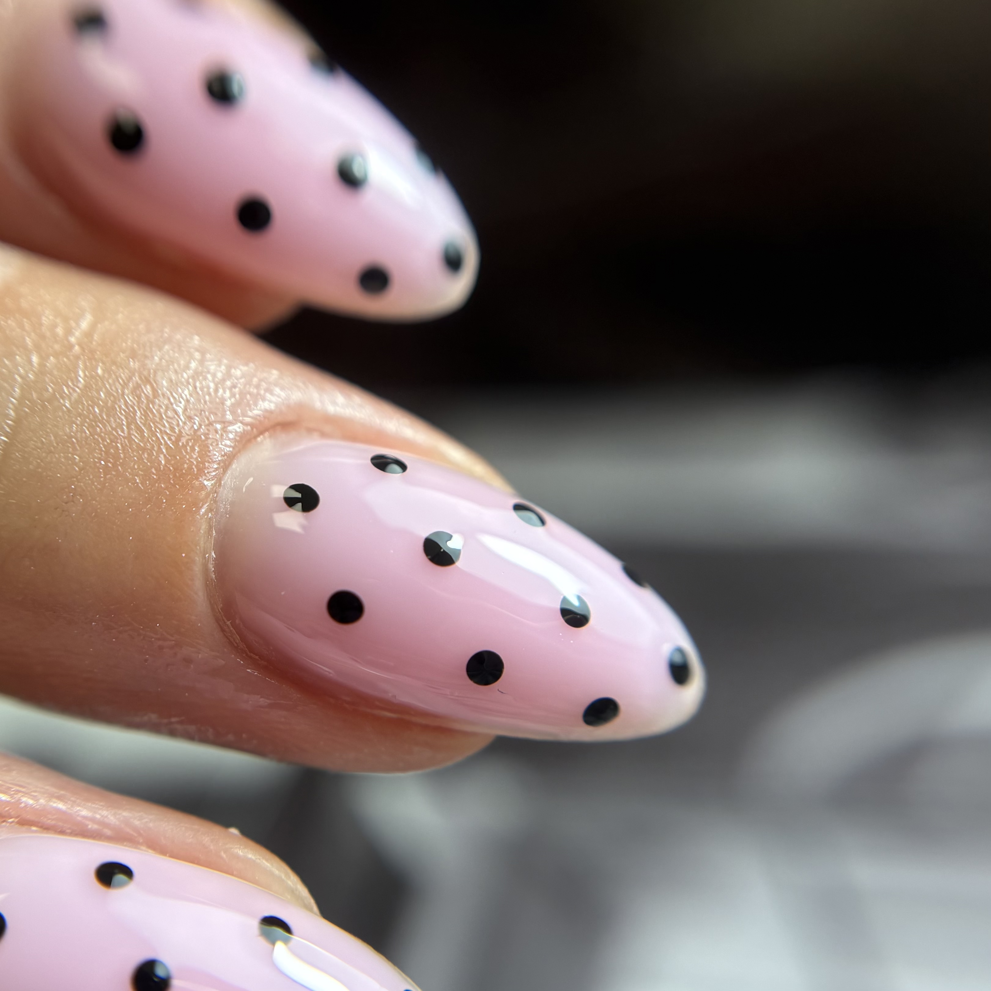 Gel nails with light pink base and black polka dot nail art