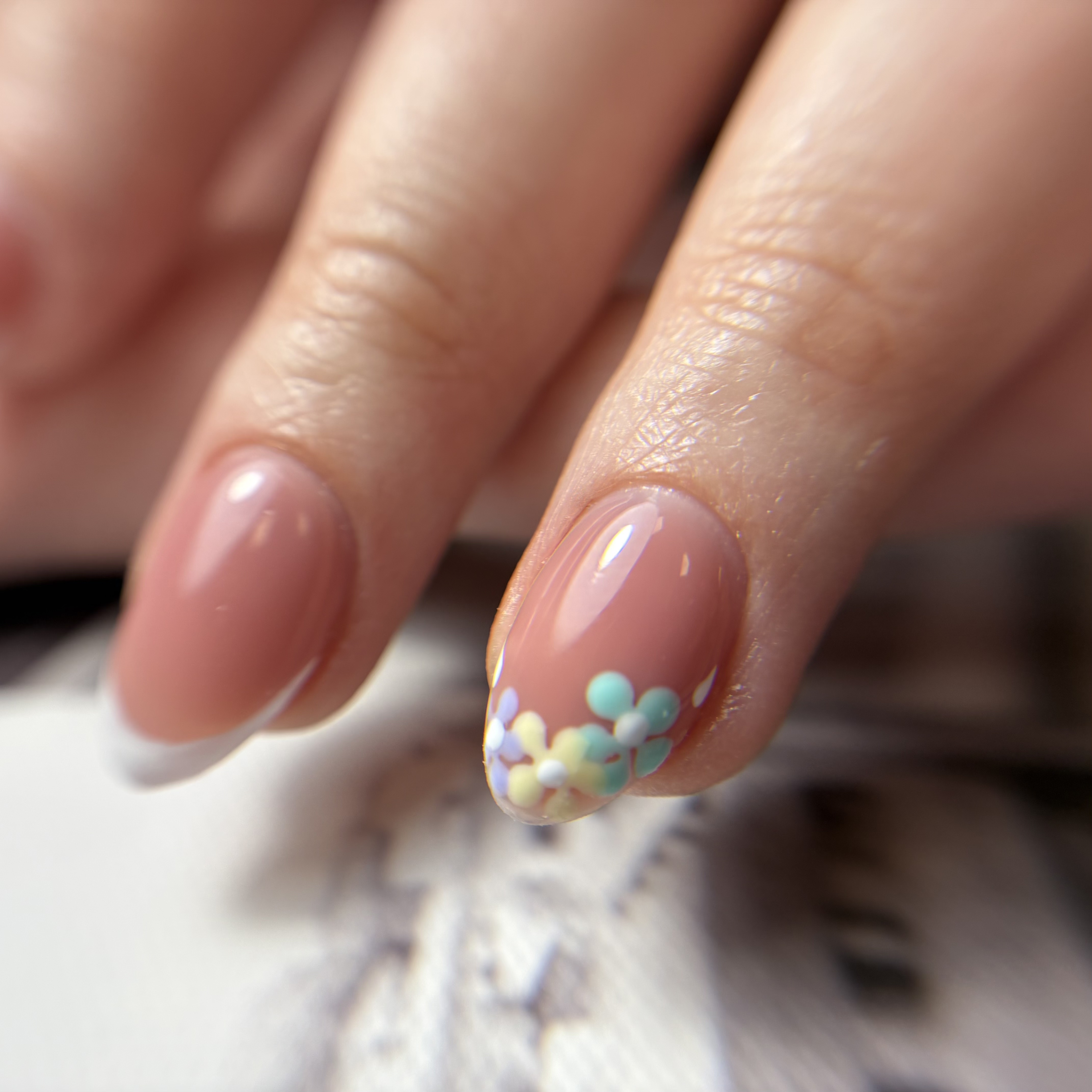 Nail art with pastel flower designs on nude gel nails